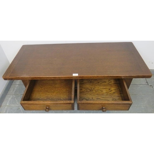 804 - A reproduction heavy oak coffee table, housing two short drawers with turned wooden knob handles, on... 