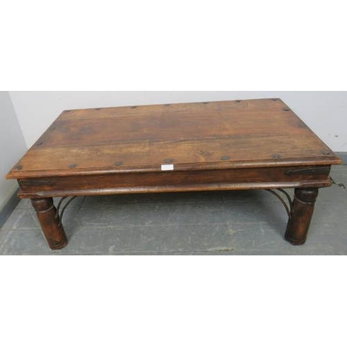 813 - A vintage mango wood Indian Thakat coffee table, with cast iron fittings, on turned supports. 
Condi... 