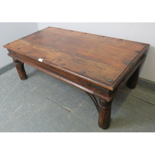 813 - A vintage mango wood Indian Thakat coffee table, with cast iron fittings, on turned supports. 
Condi... 