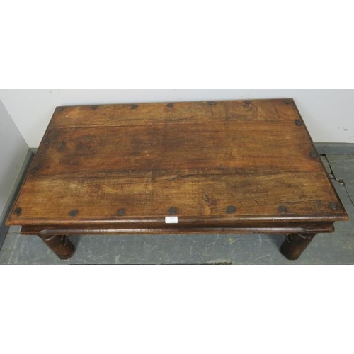 813 - A vintage mango wood Indian Thakat coffee table, with cast iron fittings, on turned supports. 
Condi... 