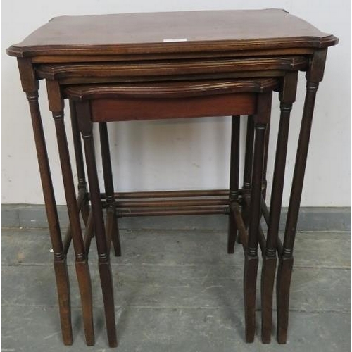 820 - A set of three Edwardian mahogany nesting tables with shaped tops, on turned supports with stretcher... 