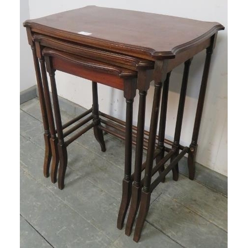 820 - A set of three Edwardian mahogany nesting tables with shaped tops, on turned supports with stretcher... 