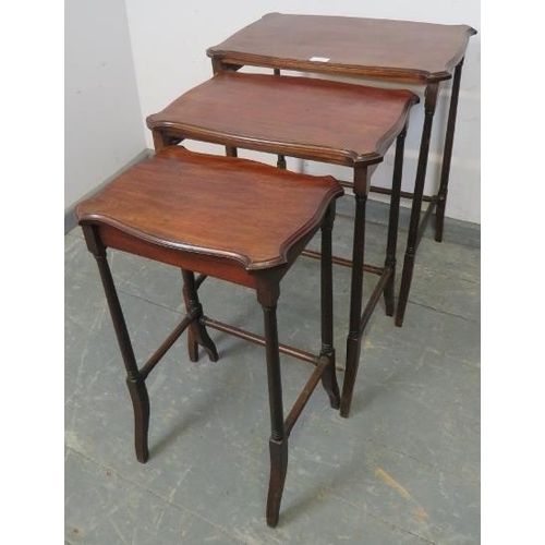 820 - A set of three Edwardian mahogany nesting tables with shaped tops, on turned supports with stretcher... 