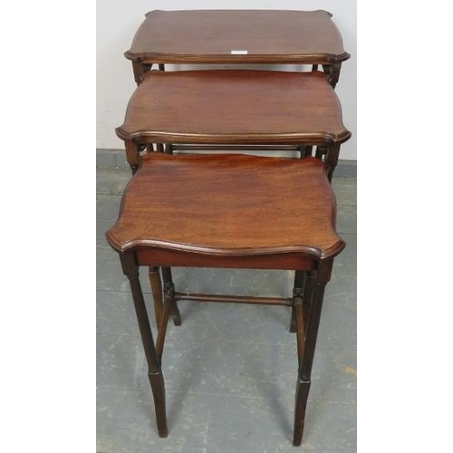 820 - A set of three Edwardian mahogany nesting tables with shaped tops, on turned supports with stretcher... 