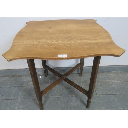 824 - An Edwardian light oak folding occasional table, the shield shaped top on a folding base. 
Condition... 