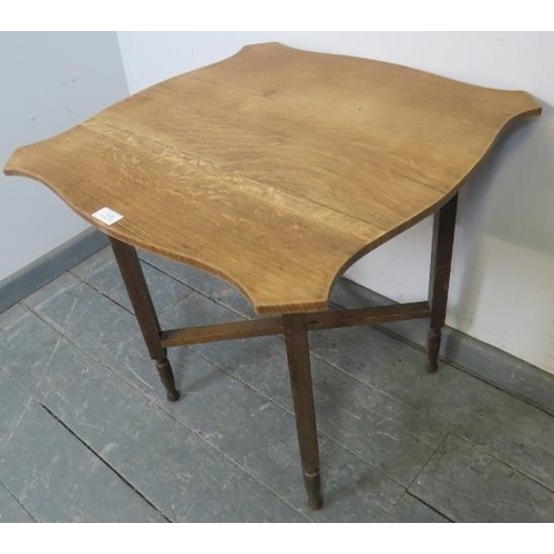 824 - An Edwardian light oak folding occasional table, the shield shaped top on a folding base. 
Condition... 