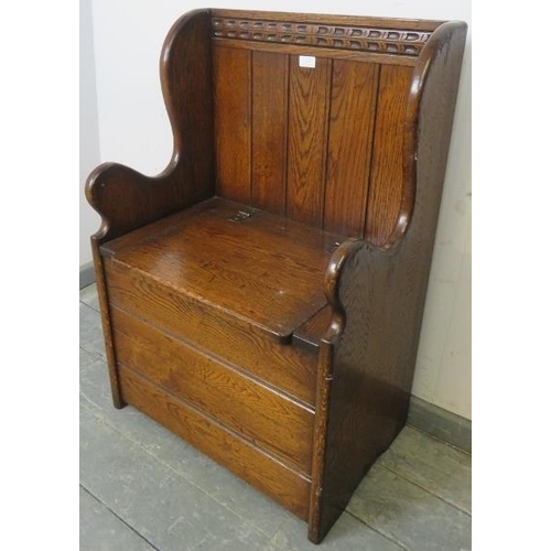 828 - A diminutive oak box settle in a 17th century taste, with chip carved top rail and shaped slab sides... 