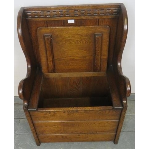 828 - A diminutive oak box settle in a 17th century taste, with chip carved top rail and shaped slab sides... 