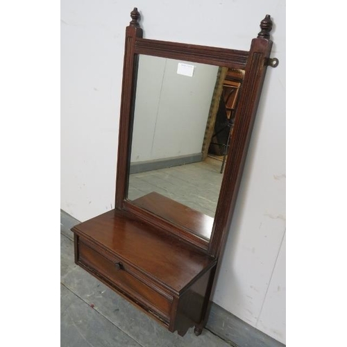 836 - An Edwardian mahogany wall mirror with reeded detail and turned finials, above a box base with fall ... 