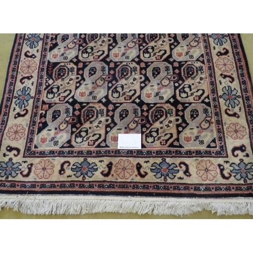 908 - A late 20th century wool rug with a repeat pattern to central field, blue/cream. 200cm x 121cm. Very... 