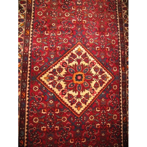 918 - A Persian Hamadan runner diamond motif to centre on claret ground. In very good condition. 322cm x 1... 