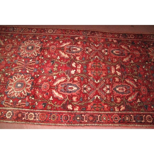 919 - A fine Persian Heriz runner, central repeat pattern on claret field. Good condition, slight colour v... 