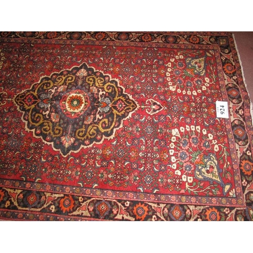 924 - A Persian Zanjan rug, central motif and 4 flower spandrels on claret ground. In good condition. 210c... 