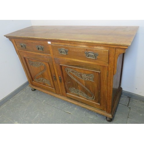 885 - An Edwardian walnut sideboard, housing two short drawers above cupboard doors with relief carving, o... 