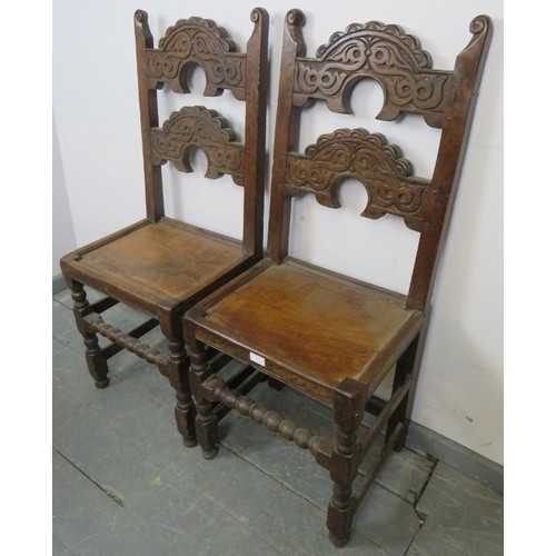 773 - A pair of 19th century oak Derbyshire chairs, with scrolled finials, the shaped backrests with relie... 