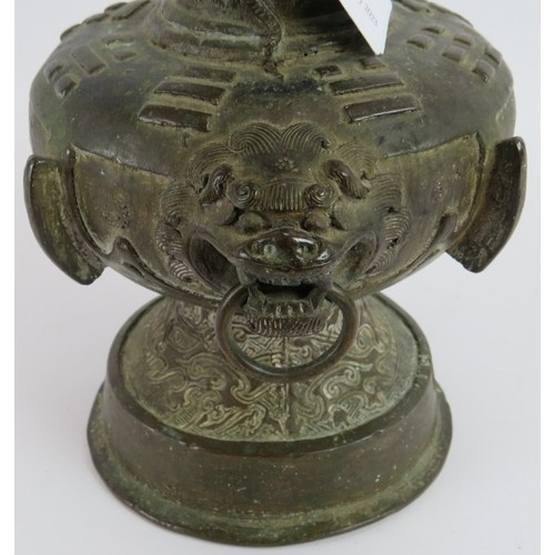 50 - An antique Chinese bronze vase in the Archaic style decorated with dragons and with lion mask handle... 