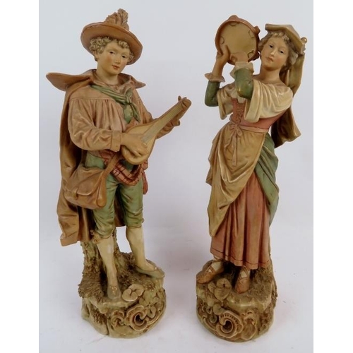 103 - A pair of Bohemia Royal Dux figures depiction a lute player and tambourine player. Height is 33.5cm.... 