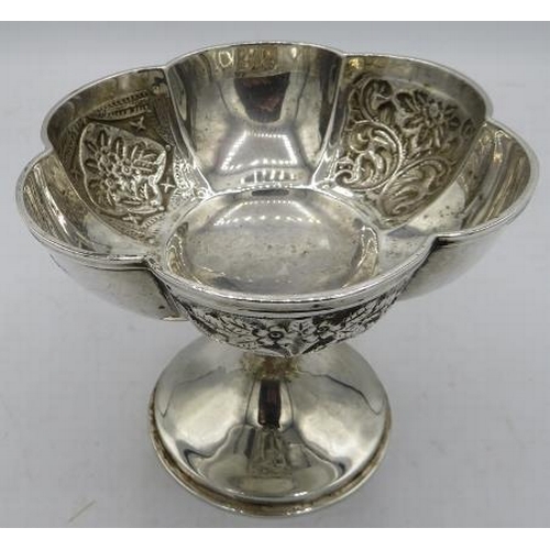 412 - A silver pedestal dish with octagonal panels, three having embossed foliate design. Approx 4