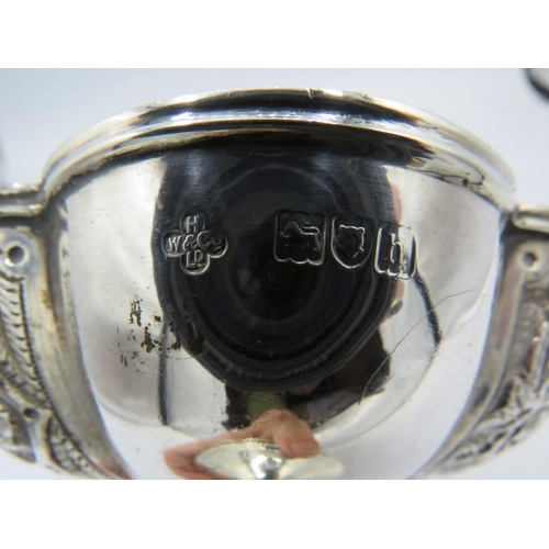 412 - A silver pedestal dish with octagonal panels, three having embossed foliate design. Approx 4