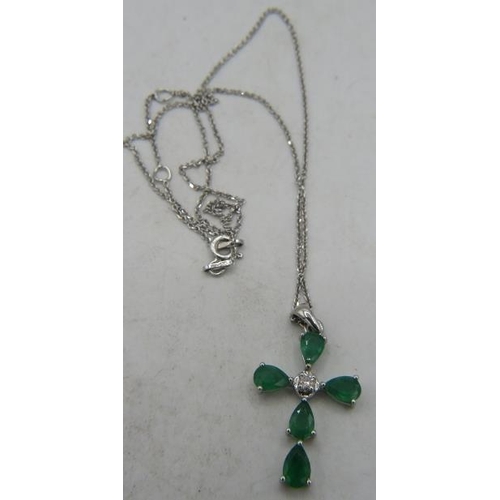 425 - A 9ct white gold pear shaped emerald & single diamond cross pendant with a silver chain. Emeralds ap... 