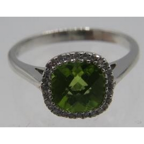 426 - An 18ct white gold cushion shaped checkerboard peridot & diamond halo ring. Peridot 1.30ct, diamonds... 