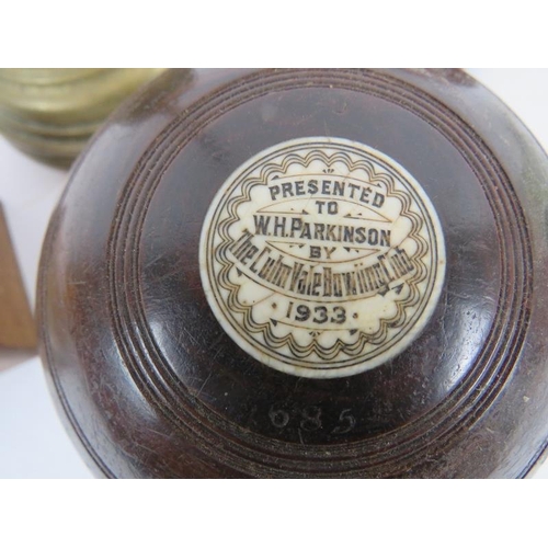 79 - Two vintage Lignum Vitae presentation lawn bowls, a vintage wooden money box and key, a brass lead f... 