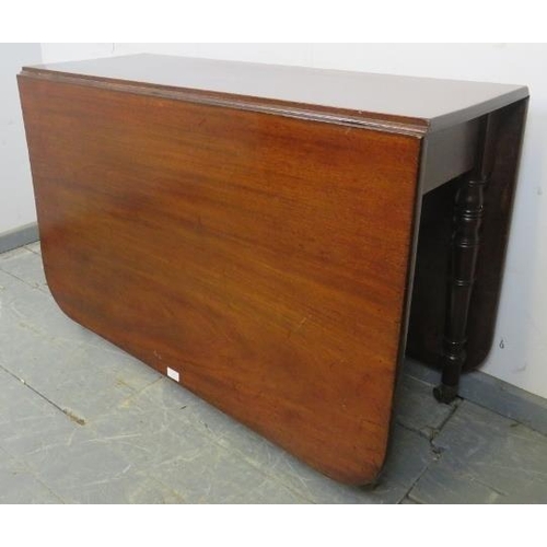 709 - An early Victorian mahogany drop-leaf dining table, on tapering turned supports with brass caps and ... 