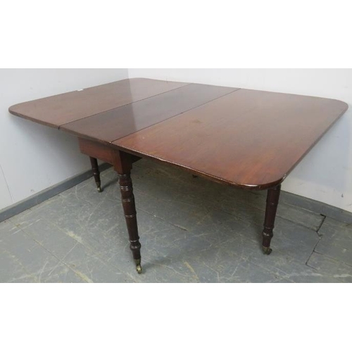 709 - An early Victorian mahogany drop-leaf dining table, on tapering turned supports with brass caps and ... 