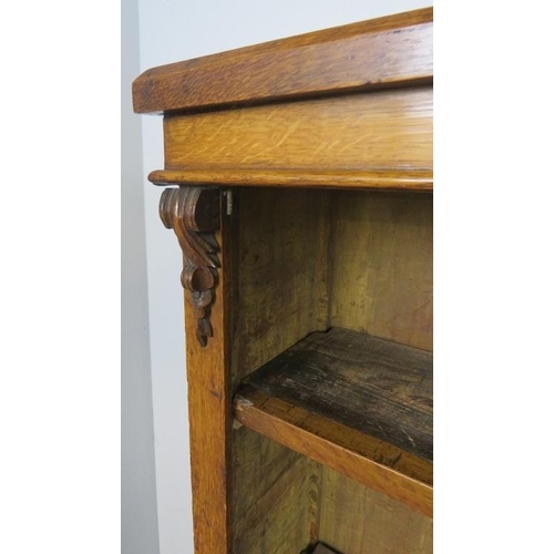 710 - A Victorian golden oak low open bookcase, of three height adjustable shelves flanked by carved corbe... 