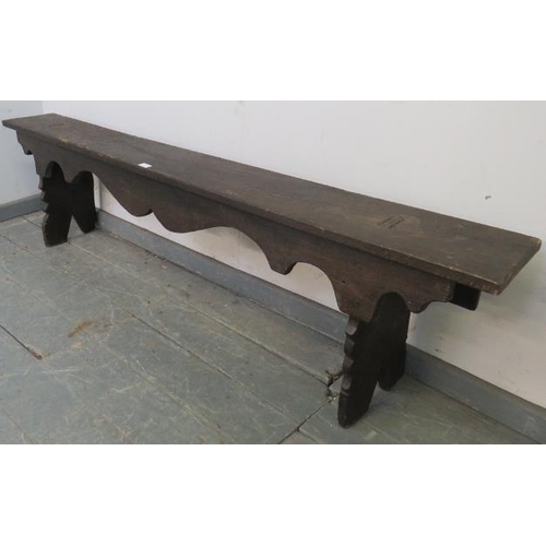 726 - An antique oak hall bench, with shaped apron, on carved stile supports. 
H44cm W183cm D22cm (approx)... 