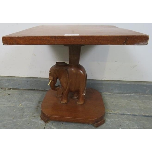 742 - A vintage teak square table with carved stand in the form of an elephant, on a plinth base with bloc... 