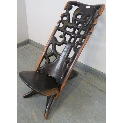 744 - A vintage lignum vitae African birthing stool, with carved and pierced backrest. 
H76cm W38cm D75cm ... 