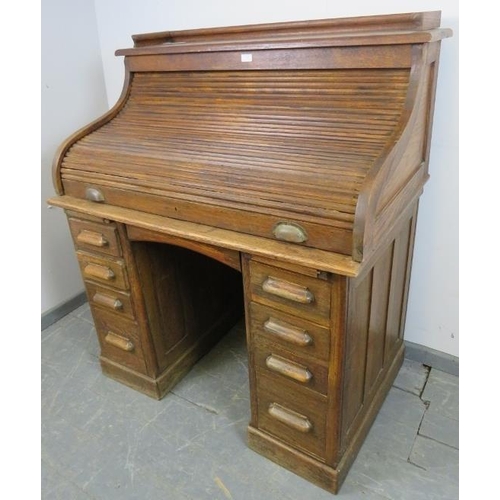 746 - An Edwardian oak ‘S-type’ roll top desk, with ¾ gallery, the fitted interior housing an array of pig... 