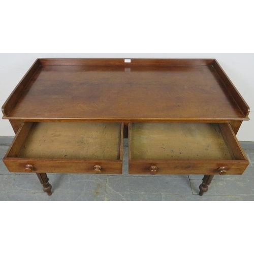 747 - A Victorian mahogany writing table, with 3/4 gallery, housing two short drawers with turned wooden k... 