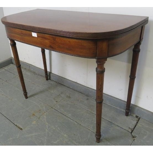 749 - A George III mahogany turnover card table, with reeded edge, on tapering turned supports. 
H71cm W91... 