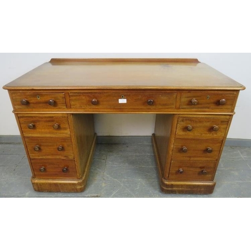 758 - A Victorian mahogany pedestal desk, housing nine graduated drawers with turned wooden knob handles, ... 