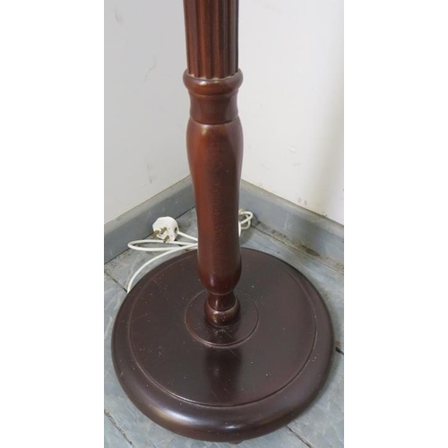 765 - A vintage mahogany standard lamp with reeded column over a circular plinth base. Includes pleated si... 