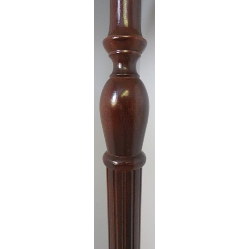 765 - A vintage mahogany standard lamp with reeded column over a circular plinth base. Includes pleated si... 