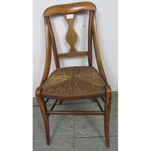 767 - A 19th century walnut child’s chair with curved sides and rush seat, on splayed supports with stretc... 