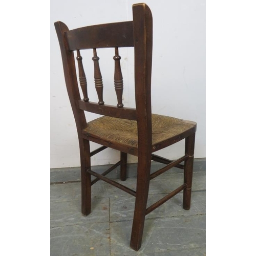 768 - A 19th century mahogany child’s chair with turned spindles and rush seat, on turned supports with st... 