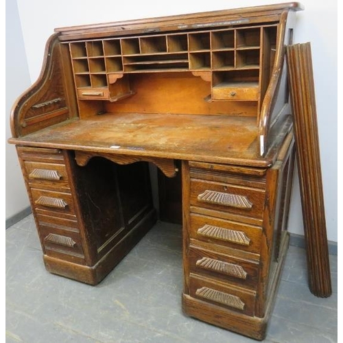 771 - An Art Deco oak ‘S-type’ roll-top desk, with fitted interior, over two pedestals housing seven gradu... 