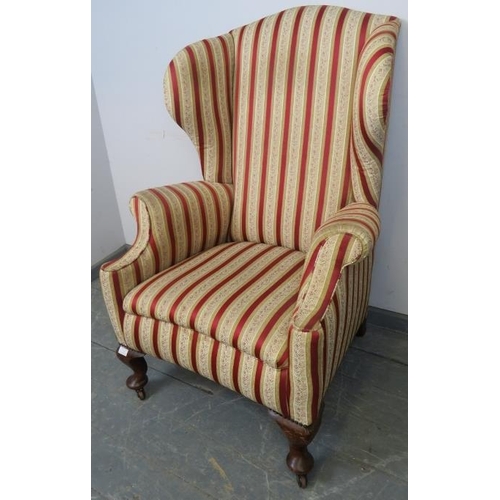 773 - A 19th century Georgian design wingback armchair, reupholstered in striped material with brass studs... 