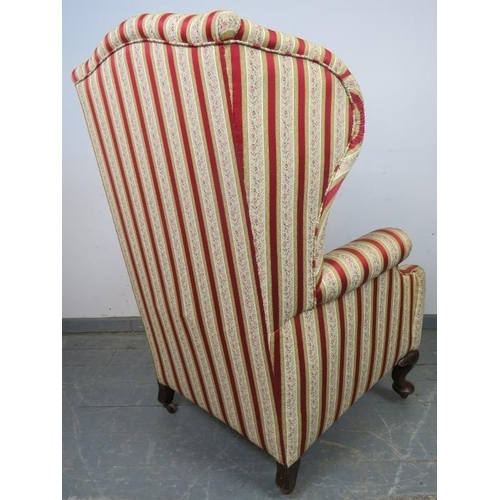 773 - A 19th century Georgian design wingback armchair, reupholstered in striped material with brass studs... 