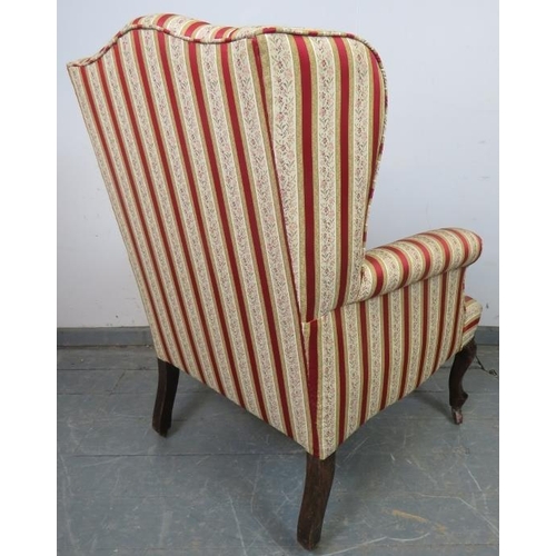 774 - An Edwardian wingback armchair, reupholstered in striped material with brass studs, on mahogany cabr... 