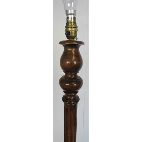 787 - A vintage mahogany standard lamp, with carved and fluted tapering column, on a circular plinth base.... 