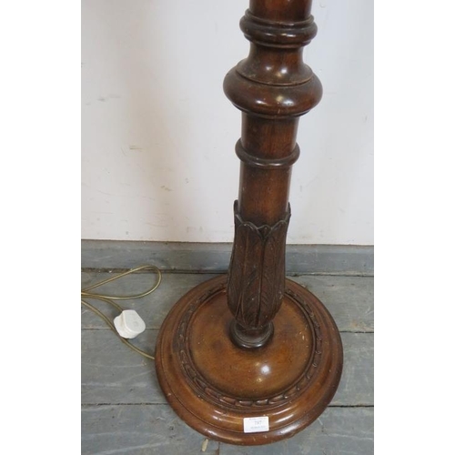 787 - A vintage mahogany standard lamp, with carved and fluted tapering column, on a circular plinth base.... 