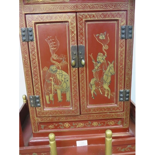 802 - A vintage Chinese temple cabinet, the red lacquer hand painted with traditional scenes and gold acce... 