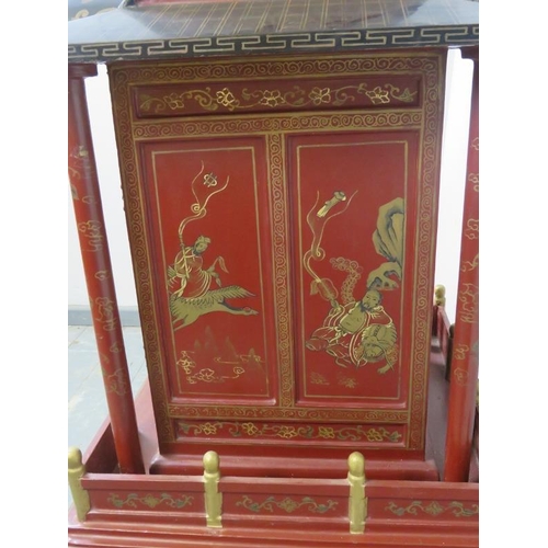 802 - A vintage Chinese temple cabinet, the red lacquer hand painted with traditional scenes and gold acce... 