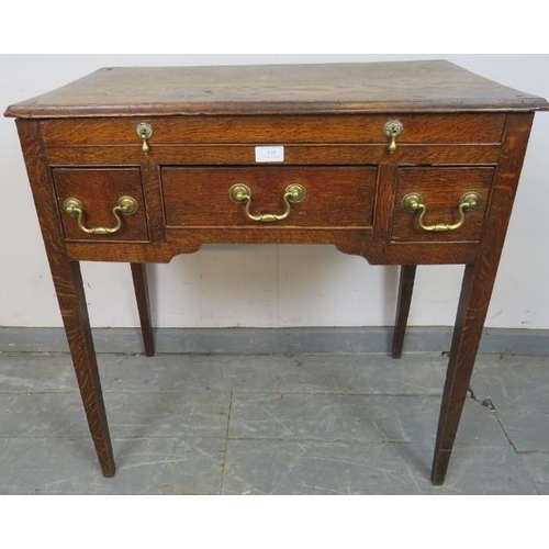 810 - An 18th century oak lowboy, housing one long drawer with brass drop handles, above one long and two ... 