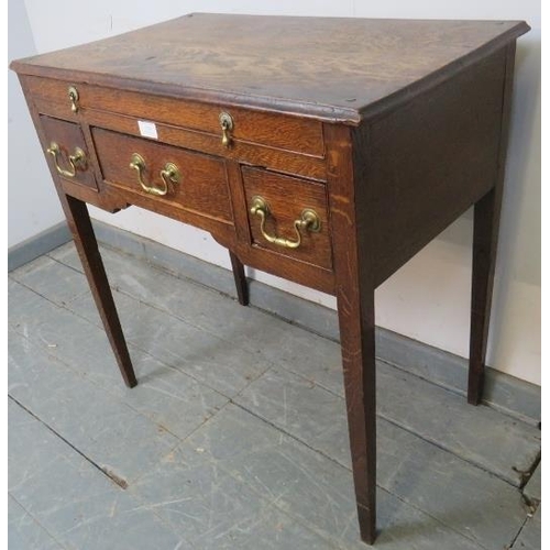 810 - An 18th century oak lowboy, housing one long drawer with brass drop handles, above one long and two ... 